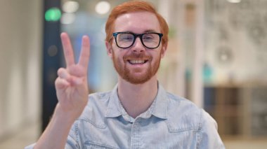 Minnettar Genç Kızıl Adam Zafer işareti gösteriyor 