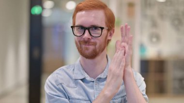 Heyecanlı genç kızıl adam alkışlıyor, tezahürat yapıyor 