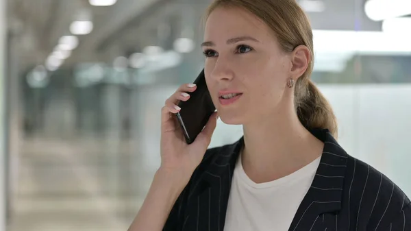 Весела молода бізнес-леді розмовляє по телефону, переговори — стокове фото
