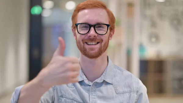 Positivo joven pelirroja hombre haciendo pulgares hacia arriba — Foto de Stock