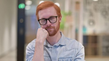 Yorgun genç kızıl adam kestiriyor.