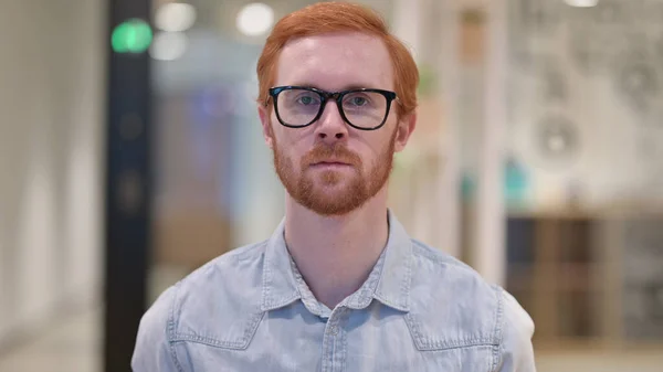 Sérieux jeune rousse homme regardant la caméra — Photo