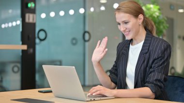 Ofisteki Laptop 'ta video görüşmesi yapan heyecanlı genç iş kadını 