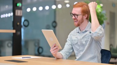 Tablette Başarı Kutlaması İçin Heyecanlı Genç Kızıl Adam 