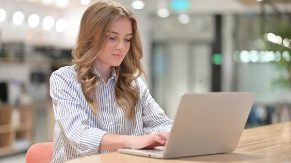 Imprenditrice focalizzata che lavora sul computer portatile in ufficio — Foto Stock