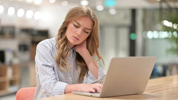 Empresária cansada com laptop com dor no pescoço no escritório — Fotografia de Stock