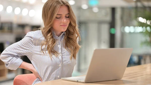 Donna d'affari stanca con computer portatile con mal di schiena in ufficio — Foto Stock