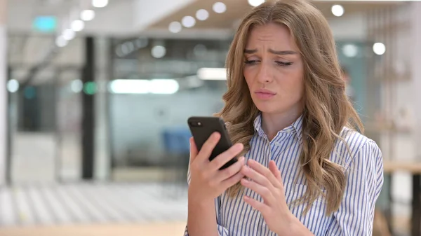 Retrato de mujer de negocios que tiene pérdida en el teléfono inteligente — Foto de Stock