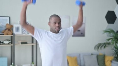 Dambıllarla egzersiz yapan Afrikalı Atletik Adam 'a yaklaş. 
