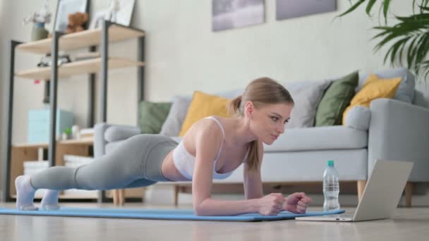 Hermosa joven haciendo plank en yoga estera en casa — Vídeo de stock