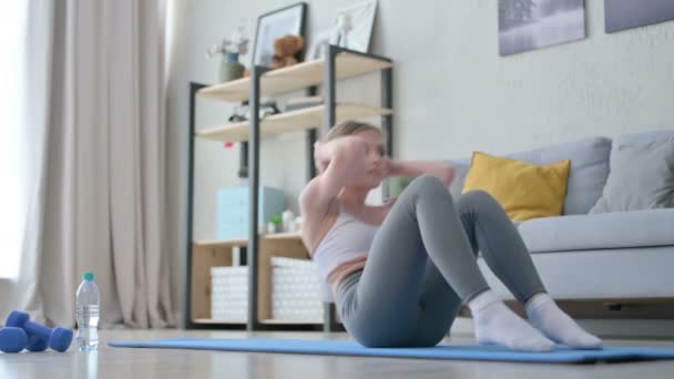 Mujer joven atlética haciendo ejercicio crujientes en estera de yoga — Vídeo de stock