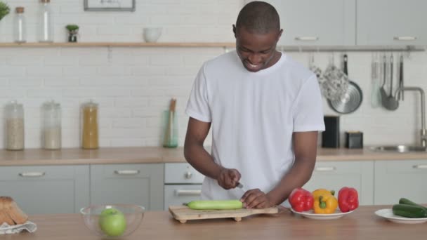 Friska afrikanska mannen Skär grönsaker i köket — Stockvideo