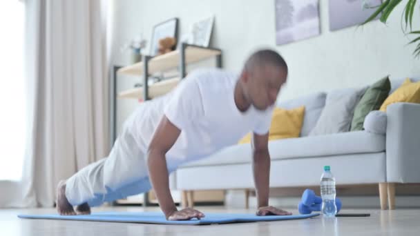 Genç Afrikalı adam evde yoga yaparken şınav çekiyor. — Stok video