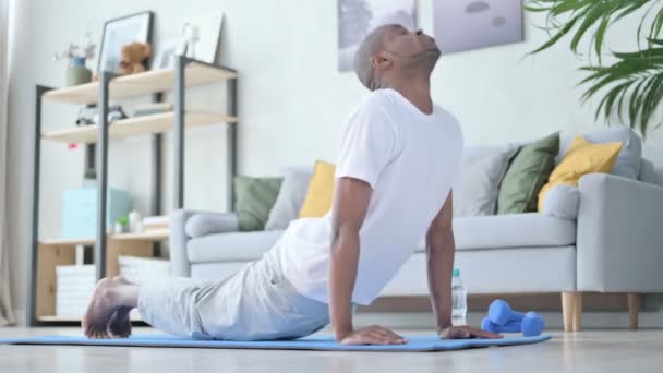 Junger Afrikaner macht zu Hause Yoga auf Yogamatte — Stockvideo
