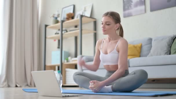 Mulher com laptop fazendo alongamentos no tapete de ioga em casa — Vídeo de Stock