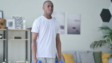 Sportif Afrikalı Adam Dambıllarla evde çalışıyor