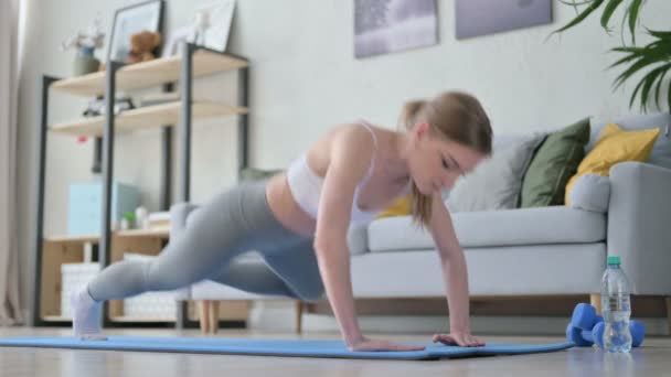 Mujer joven haciendo ejercicio sobre estera de yoga en casa — Vídeo de stock