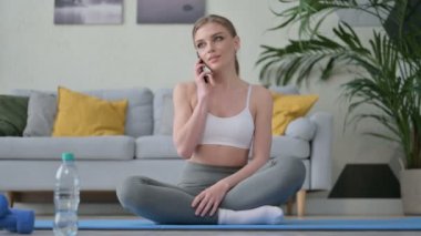 Evde Yoga Mat 'te Akıllı Telefonla Konuşan Genç Kadın