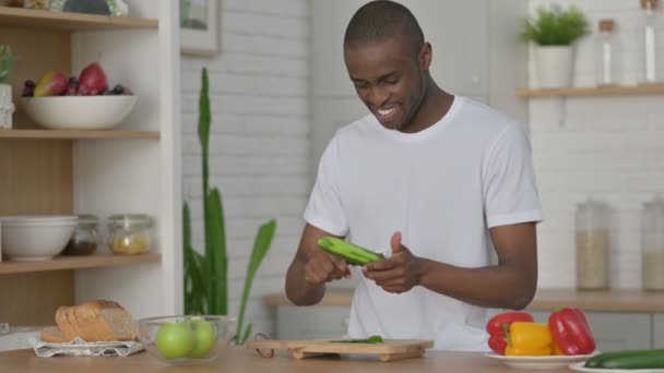 Sano africano uomo peeling cetriolo in cucina — Video Stock