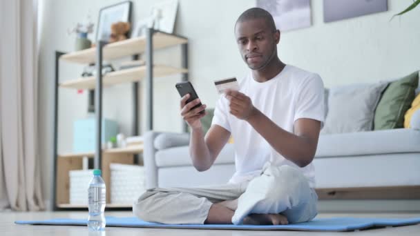 Afrikaner macht Online-Zahlung per Smartphone auf Yogamatte — Stockvideo