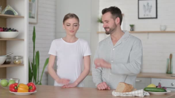 Heureux jeune couple faire coeur forme avec les mains dans cuisine — Video