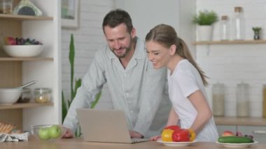 Kadın ve Adam Mutfaktaki Bilgisayarda Video Konuşması Yapıyor