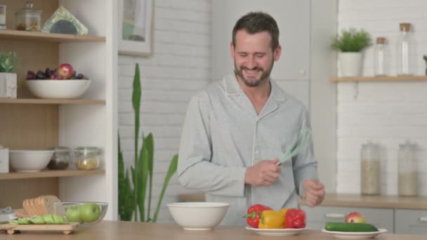 Gesunder junger Mann tanzt beim Kochen in der Küche — Stockvideo