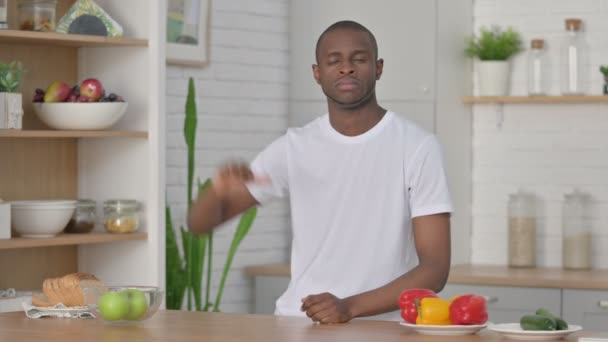 Sportivo africano uomo mostrando pollici giù mentre in piedi in cucina — Video Stock