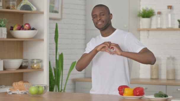 Homme africain athlétique faisant forme de coeur par les mains tandis que dans la cuisine — Video