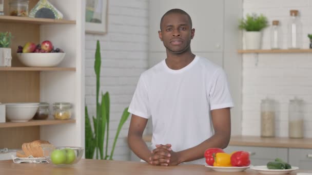 Sporty Αφρικής άνθρωπος κοιτάζοντας την κάμερα, ενώ στέκεται στην κουζίνα — Αρχείο Βίντεο