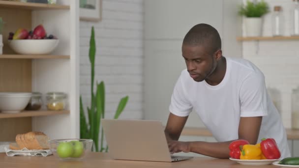 Αθλητικός Αφρικανός που εργάζεται σε Laptop στην κουζίνα — Αρχείο Βίντεο