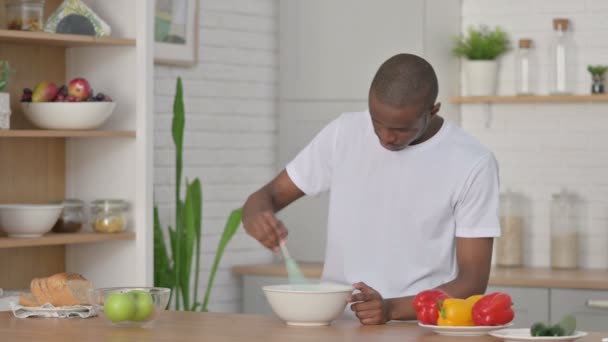 Sano africano uomo focalizzato mentre cucina in cucina — Video Stock