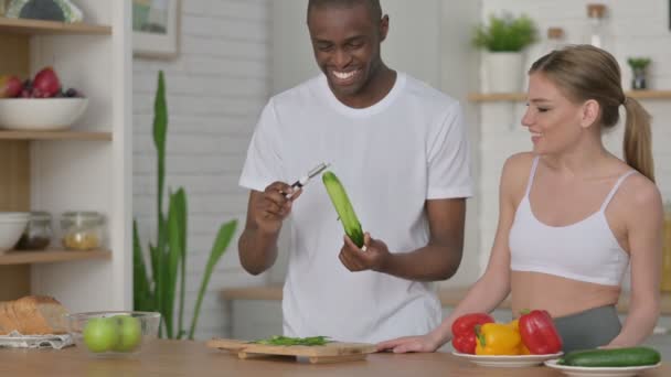 Pareja atlética pelando pepino en la cocina — Vídeo de stock