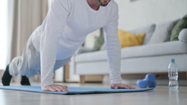 Close up de homem desportivo fazendo flexões no tapete de ioga em casa — Vídeo de Stock