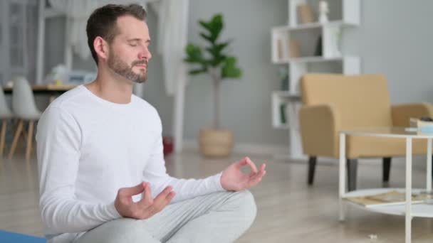 Peaceful Man Meditating on Yoga Mat at at Home — стоковое видео