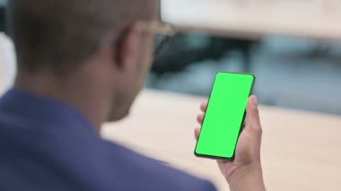 Krom Ekran ile Akıllı Telefon kullanan Genç İşadamının Arka Görünümü 