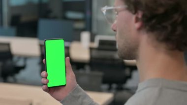 Krom Ekran ile Akıllı Telefon kullanan Genç İşadamının Arka Görünümü 