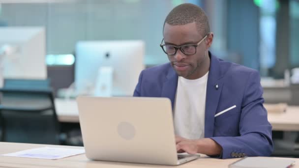 Afrikanischer Geschäftsmann mit Laptop lächelt in Kamera — Stockvideo
