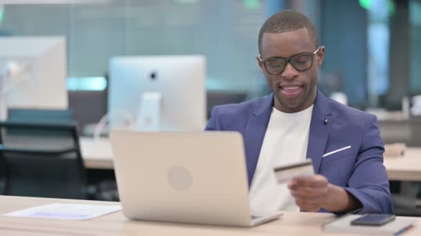 Успешная онлайн-оплата ноутбука африканским бизнесменом — стоковое видео