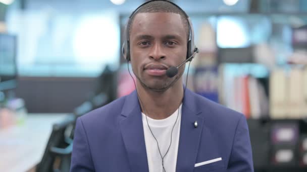 Πορτρέτο του αφρικανού επιχειρηματία με ακουστικά κοιτάζοντας κάμερα — Αρχείο Βίντεο