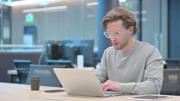 Framgångsrik ung affärsman firar på laptop på jobbet — Stockvideo