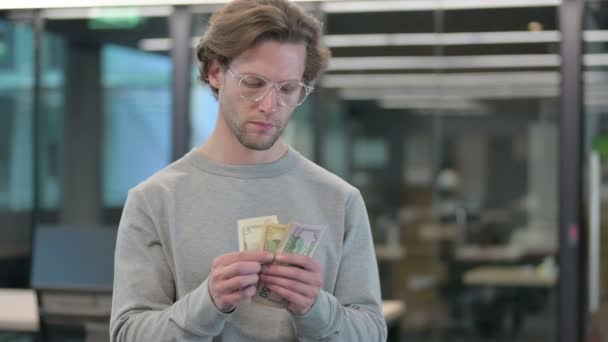 Porträt eines jungen Geschäftsmannes, der Dollar zählt — Stockvideo