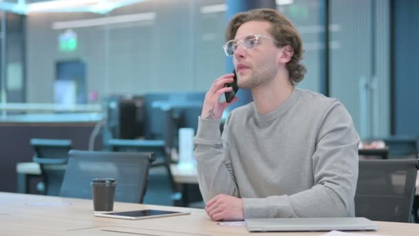 Fiatal üzletember Okostelefonon beszél az irodában — Stock videók