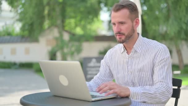 Succès Moyen Age homme Célébration sur ordinateur portable dans un café en plein air — Video