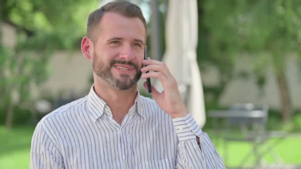 Retrato al aire libre del hombre de mediana edad que habla en el teléfono inteligente — Vídeos de Stock