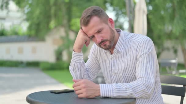 Hombre de mediana edad sintiéndose preocupado mientras piensa en el café al aire libre — Vídeos de Stock