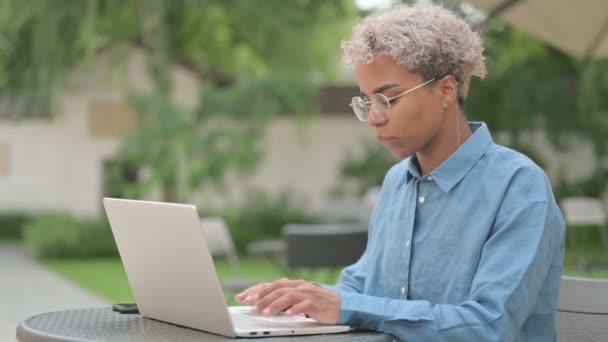 Femeie africană tânără cu cap de tremurat laptop ca da conectați-vă la cafeneaua în aer liber — Videoclip de stoc