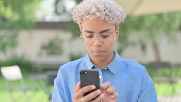 Retrato da jovem mulher africana comemorando no smartphone — Vídeo de Stock