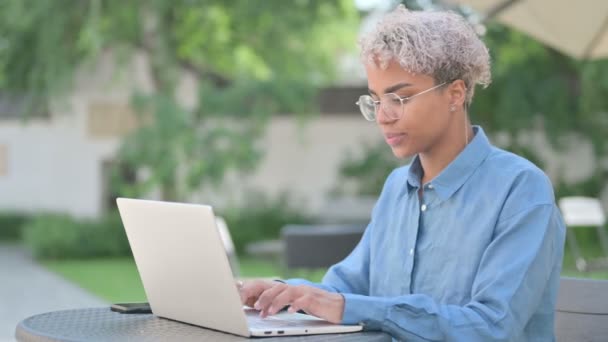 Jovem mulher africana trabalhando no laptop no café ao ar livre — Vídeo de Stock