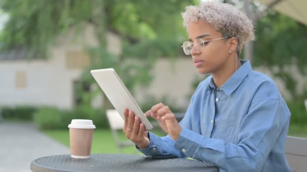 Atractiva joven africana usando tableta en café al aire libre — Vídeo de stock